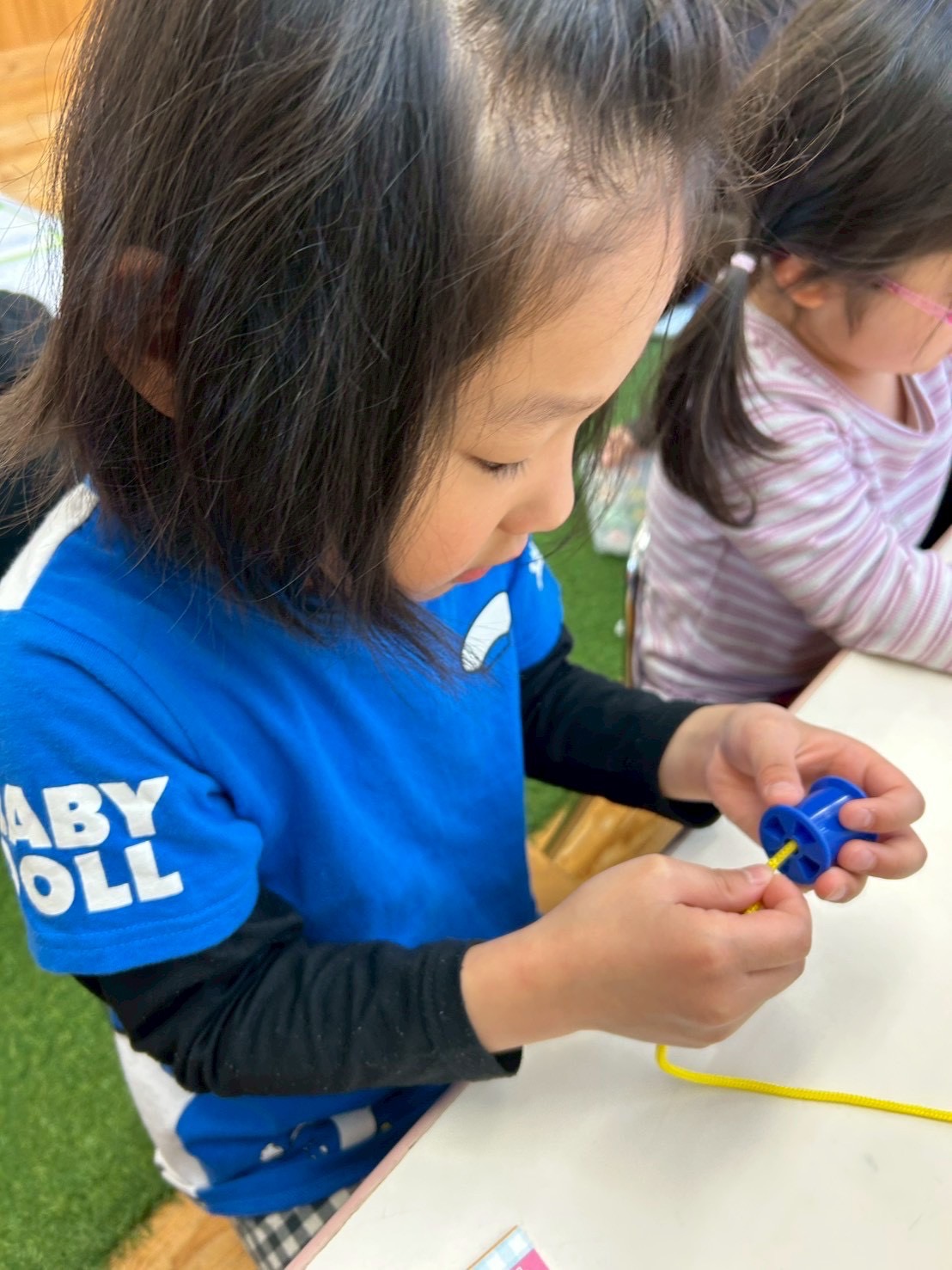 ひも通し活動に集中して取り組むお子様の様子